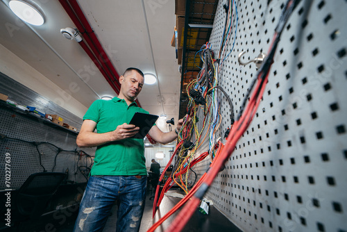 Young engineer check and restores electrical wiring from tractor