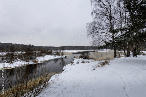 winter river in the middle of a snowy landscape. snowy coast © Sergei