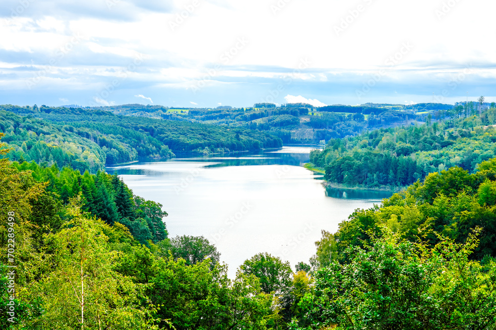 View of the Wiehltalsperre and the surrounding green nature. Idyllic landscape by the lake in the nature reserve near Reichshof in North Rhine-Westphalia.
