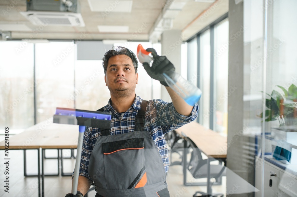 Male professional cleaning service worker cleans the windows and shop windows of a store with special equipment Male professional cleaning service worker cleans the windows and shop windows of a store with special equipment