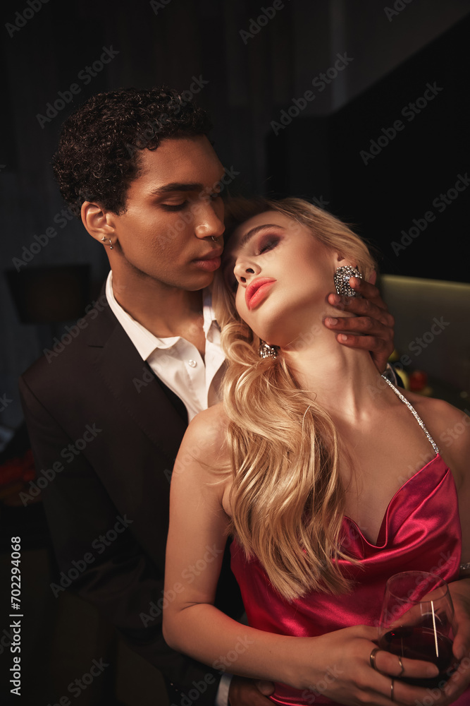 alluring sensual multicultural couple in evening attires with accessories hugging lovingly alluring sensual multicultural couple in evening attires with accessories hugging lovingly