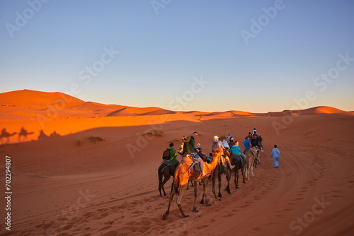 Tourists riding camels, smiling, in the Sahara Desert © Ryzhkov Oleksandr