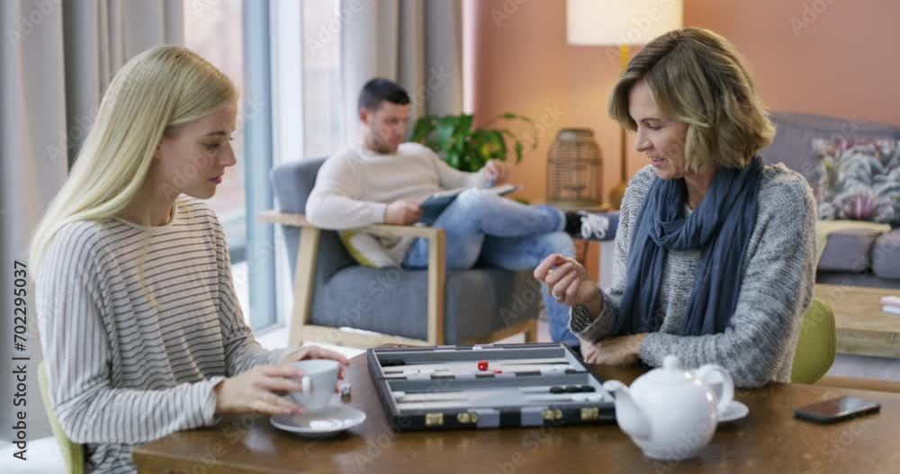 Woman, board game or mom playing backgammon in living room for fun, strategy or bonding at home. Relax, mother and daughter drinking tea in a family together on holiday with dice, challenge or parent Woman, board game or mom playing backgammon in living room for fun, strategy or bonding at home. Relax, mother and daughter drinking tea in a family together on holiday with dice, challenge or parent