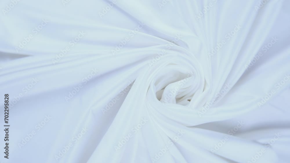 Shiny white flowing cloth texture shot in close up view macro shot. Wavy clean silk weave material. Textile satin abstract background. Bed sheet, curtain and clothing industry concept. Shiny white flowing cloth texture shot in close up view macro shot. Wavy clean silk weave material. Textile satin abstract background. Bed sheet, curtain and clothing industry concept.