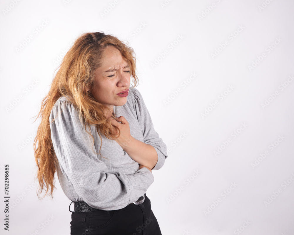 Photograph of white latina woman on light background with breast pains. Concept of health. Photograph of white latina woman on light background with breast pains. Concept of health.