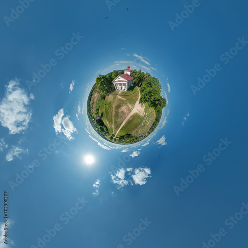 Fototapeta Naklejka Na Ścianę i Meble -  little planet transformation of spherical panorama 360 degrees overlooking church in center of globe in blue sky. Spherical abstract aerial view with curvature of space.