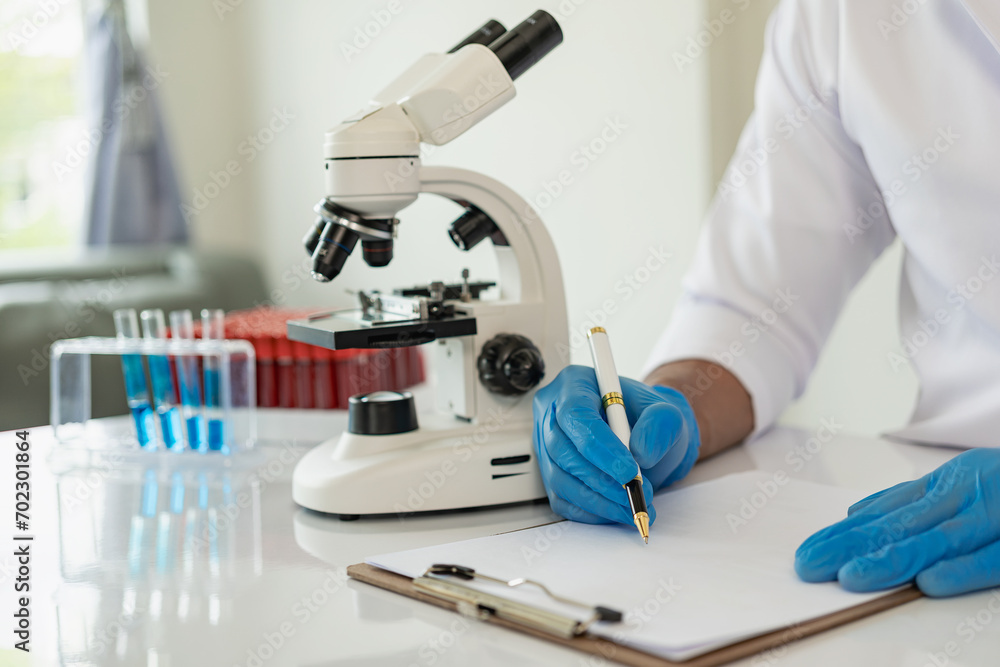 Laboratory concept: Close-up of chemicals in a laboratory, a biochemist is conducting experiments in a controlled environment in a laboratory. Doctor wearing gloves holding a test tube Laboratory concept: Close-up of chemicals in a laboratory, a biochemist is conducting experiments in a controlled environment in a laboratory. Doctor wearing gloves holding a test tube