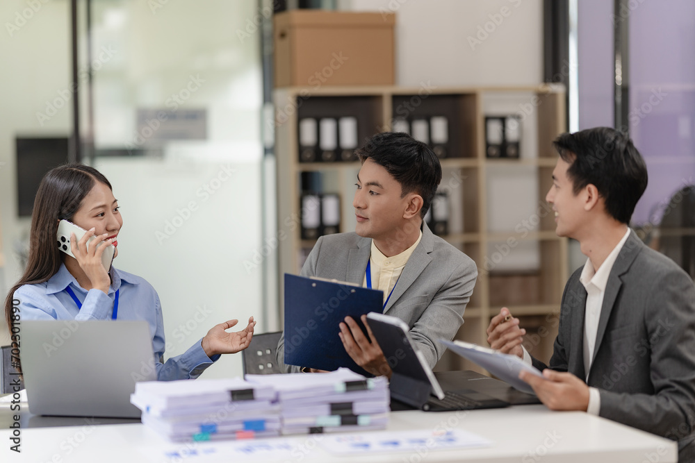 Team of successful Asian businessmen in suits working in conference room to discuss brainstorming, computation, analysis together on company growth goals and gross profit margins. Team of successful Asian businessmen in suits working in conference room to discuss brainstorming, computation, analysis together on company growth goals and gross profit margins.
