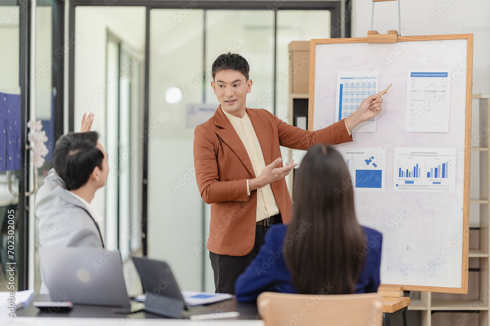 Obraz premium Team of successful Asian businessmen in suits working in conference room to discuss brainstorming, computation, analysis together on company growth goals and gross profit margins.