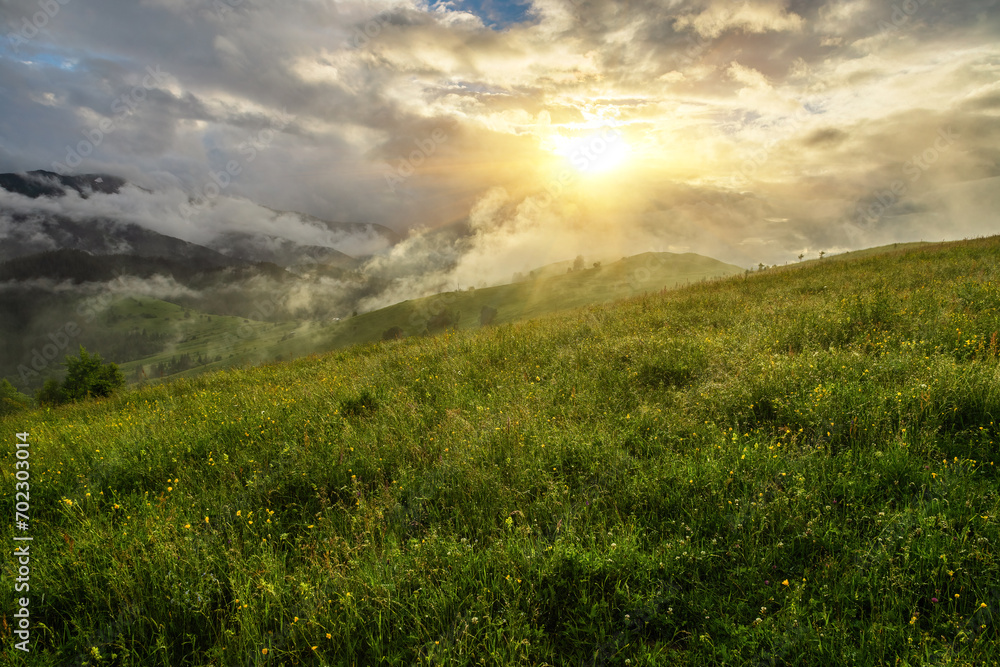 Φωτογραφία The mountain landscape, the ray of the sun made its way through the clouds and fog and illuminated the mountain meadows