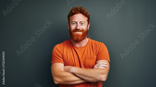 Headshot of red haired serious young male blogger looks confidently at camera, thinks about new content of his web page, dressed casually, isolated over dark studio background