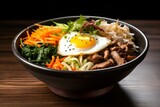 Asian food concept: bowl bibimbap with fried agg, beef and vegetables.