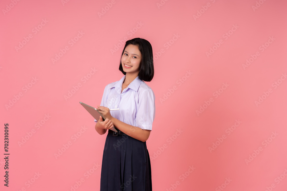 Asian female student presenter for world education Holding tablet and pen, smiling cutely Study at famous schools and tutoring institutes Taking photos in a pink background studio Asian female student presenter for world education Holding tablet and pen, smiling cutely Study at famous schools and tutoring institutes Taking photos in a pink background studio
