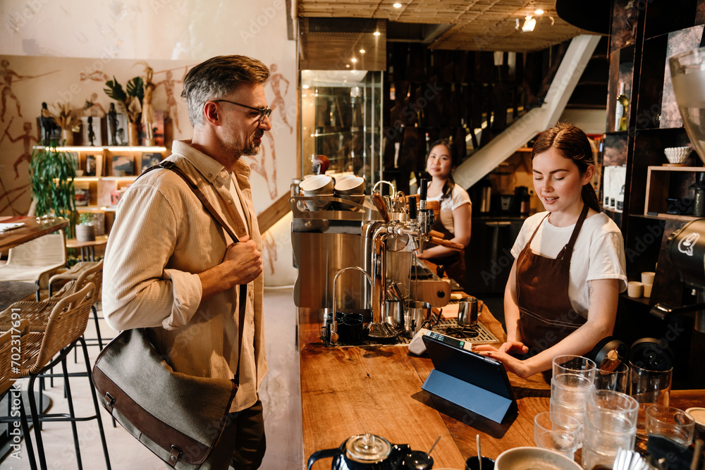 Man ordering coffee while standing in cafe Man ordering coffee while standing in cafe