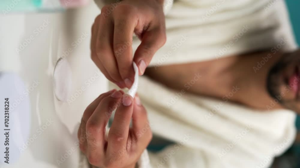 Close-up of hands of man using toner and cotton pad to remove makeup Close-up of hands of man using toner and cotton pad to remove makeup