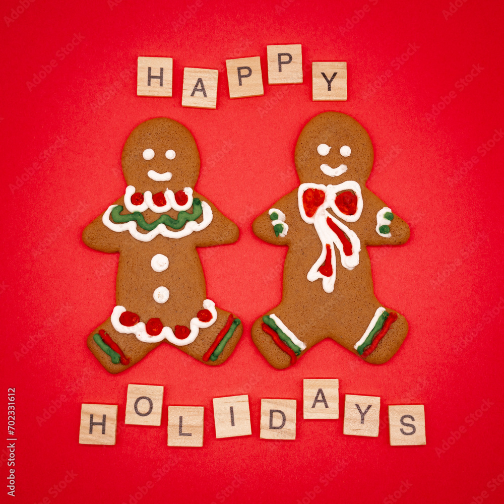 Fototapeta premium gingerbread man and christmas cookies on a red background Happy Holidays wording