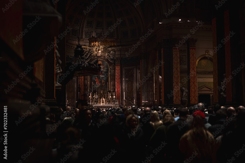 Witness the quiet reverence as people gather along the church aisle for a service in London. The hushed whispers and shared prayers create an intimate atmosphere of spiritual connection.