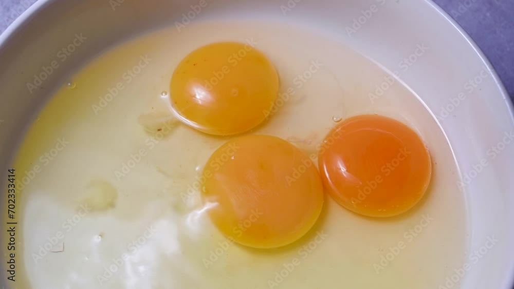 Raw egg yolk dripping down in a bowl. Cooking pastry or breakfast. Protein food Raw egg yolk dripping down in a bowl. Cooking pastry or breakfast. Protein food