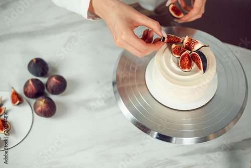 Confectioner decorates bento cake with figs photo