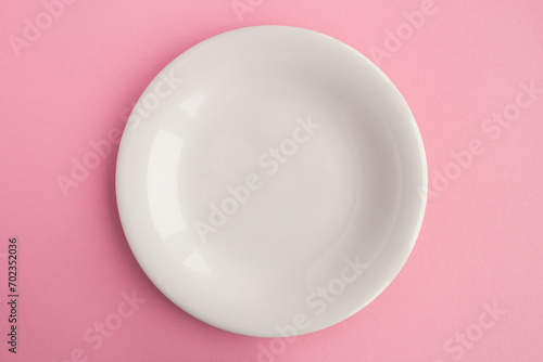 Empty white plate for text on the pink background. Copy space. Top view.