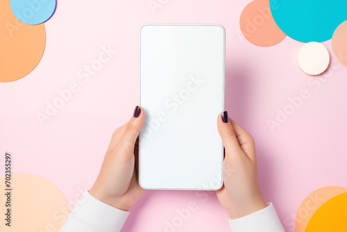 woman's hands close-up holds smartphone with empty white screen, pastel background photo