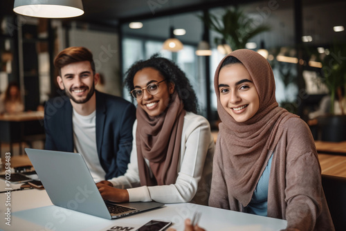 Young woman showing something on the laptop to her friends on university