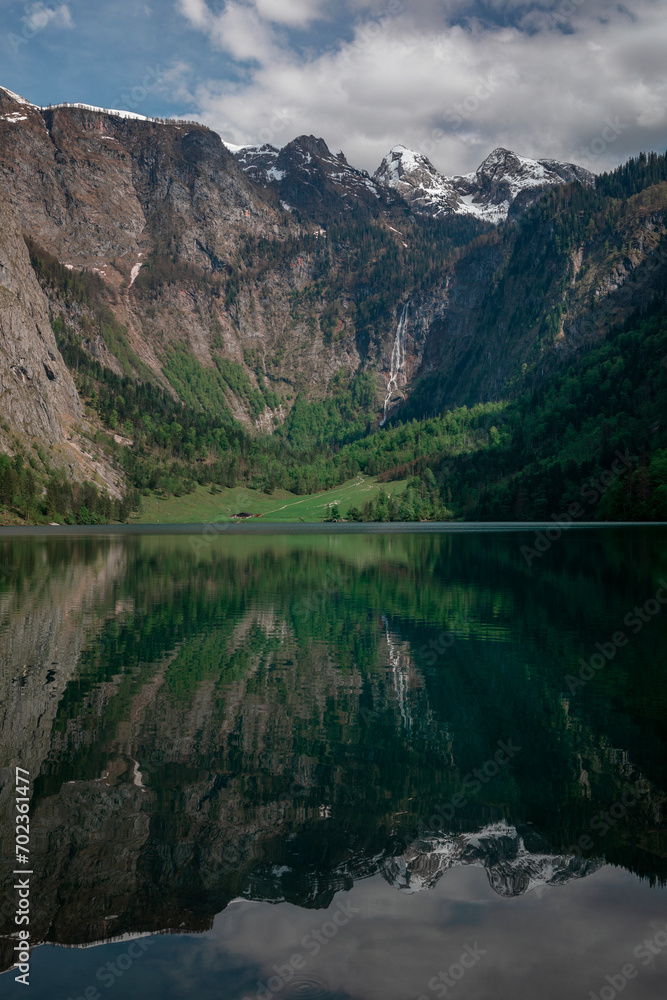 Steep mountain cliffs at lake Obersee reflecting on water surface, Berchtesgaden Bavaria.