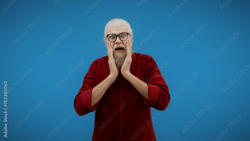 Stylish senior man holds his head in his hands in surprise, overwhelmed by shocking news and amazement Stylish senior man holds his head in his hands in surprise, overwhelmed by shocking news and amazement