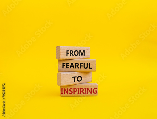 From Fearful to Inspiring symbol. Concept words From Fearful to Inspiring on wooden blocks. Beautiful yellow background. Business and From Fearful to Inspiring concept. Copy space.