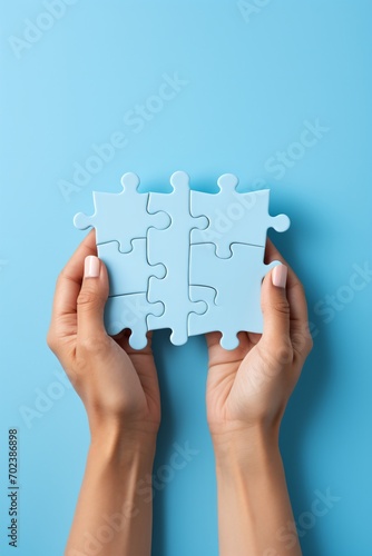 Blue puzzle pieces in hands on blue background,