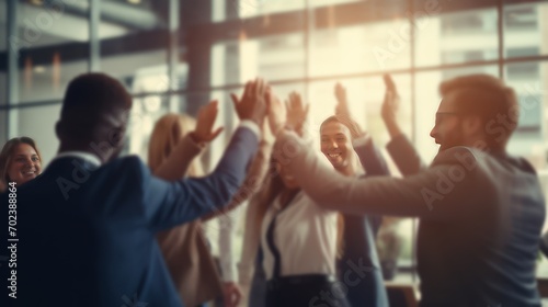 Blurred image of a diverse business team happily celebrating success and having fun together, high-fiving and cheering. photo
