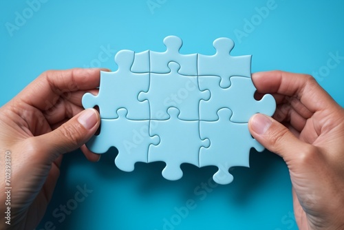 Blue puzzle pieces being put together by a person,