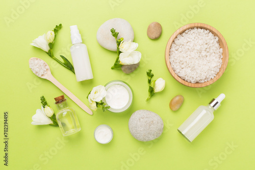Flat lay with spa products and flowers on color background