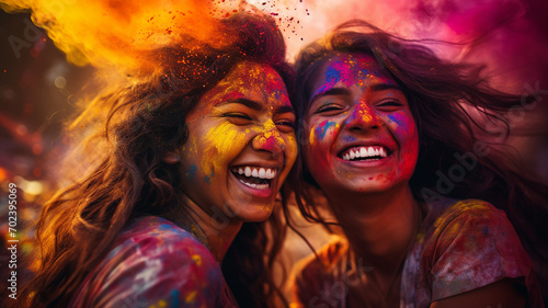 Portrait of happy young women with holi powder against colourful background