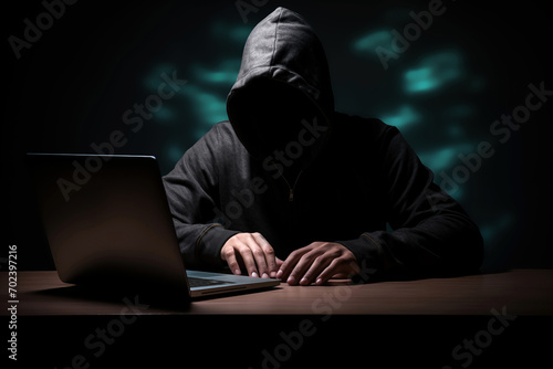 hacker hooded computer cracking digital code to hack into the mainframe of a network and disrupt systems to black mail, hold to ransom or take down companies, products or service