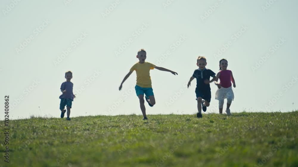 Three Boys and a Girl Run Across the Meadow Towards the Camera on a Sunny Day. Concept of Aspiring Athlete, Summer Olympics, Paris 2024 Three Boys and a Girl Run Across the Meadow Towards the Camera on a Sunny Day. Concept of Aspiring Athlete, Summer Olympics, Paris 2024