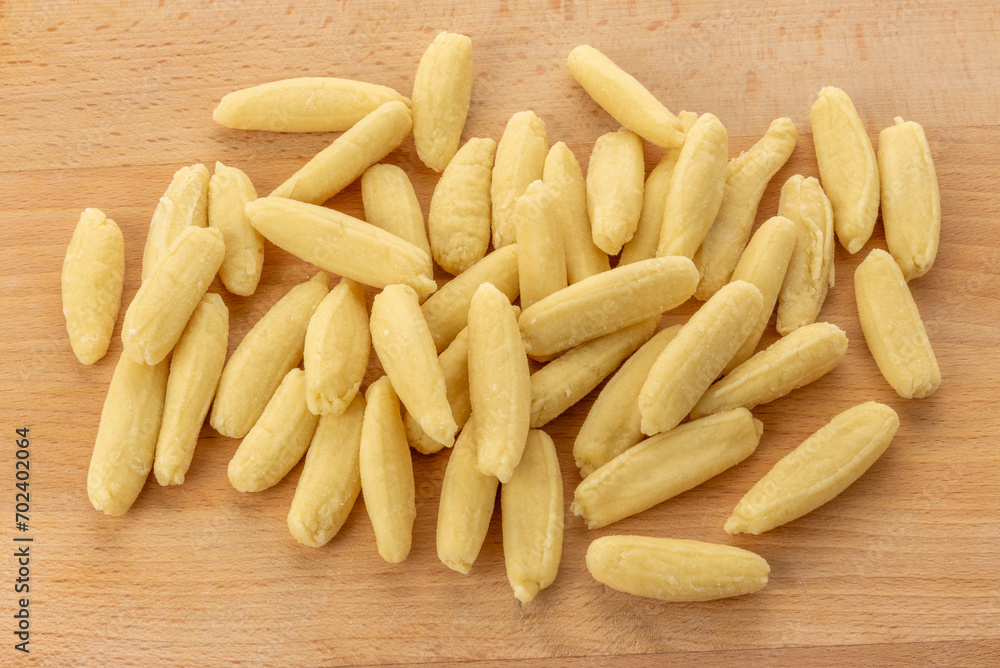 Ravioles de Melle typical gnocchi from Val Varaita, Piedmont, Italy made with potatoes, flour and cheese. Raw gnocchi on a wooden cutting board Ravioles de Melle typical gnocchi from Val Varaita, Piedmont, Italy made with potatoes, flour and cheese. Raw gnocchi on a wooden cutting board