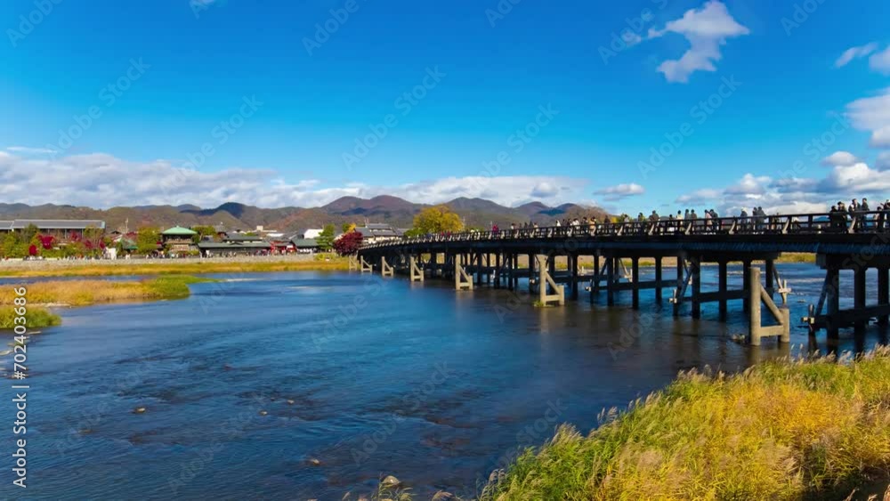 A timelapse of cloud and tourists near Togetsukyo bridge in Kyoto wide shot tilt A timelapse of cloud and tourists near Togetsukyo bridge in Kyoto wide shot tilt