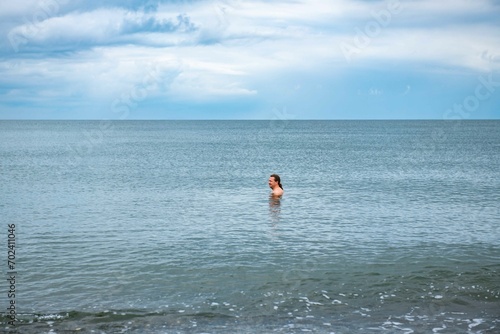 One man swims in the sea in summer