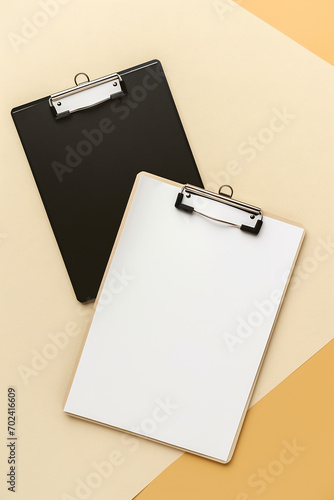 view of black and white clipboards on a soft beige background