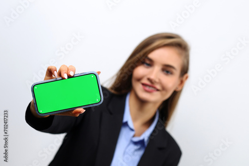 Cute female secretary showing smartphone green screen