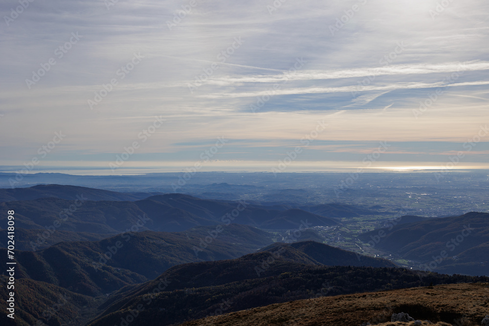 Vista ampia del territorio della regione Friuli Venezia Giulia, che si estende dalle montagne ad est, fino alle sponde del mare Adriatico a sud, durante un pomeriggio autunnale con cielo nuvoloso Vista ampia del territorio della regione Friuli Venezia Giulia, che si estende dalle montagne ad est, fino alle sponde del mare Adriatico a sud, durante un pomeriggio autunnale con cielo nuvoloso