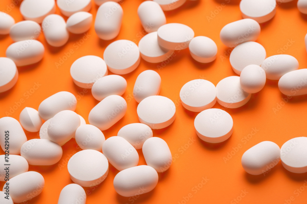 A Scattering of White Pills on an Orange Surface