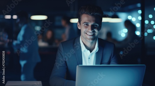 Late at Night in Private Office white male Businessman Works on a Laptop Computer. He Look at the Camera with Smile. Data Protection Engineering Network for Cyber Security, generative ai