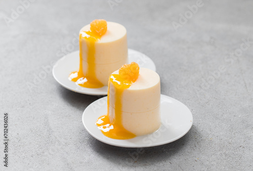 Fotografie Vegan Tangerine Panna Cotta of cylindrical shape with tangerine sauce