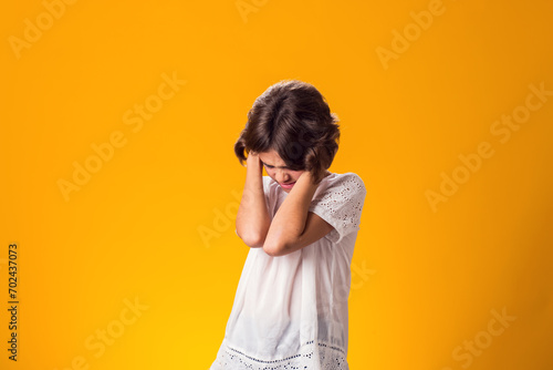 Girl ignoring stressful environment, closed ears with hands photo