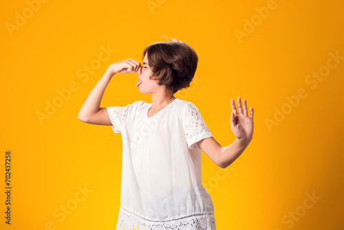 Kid girl feeling bad and dislike smell and hold nose from funny odor photo