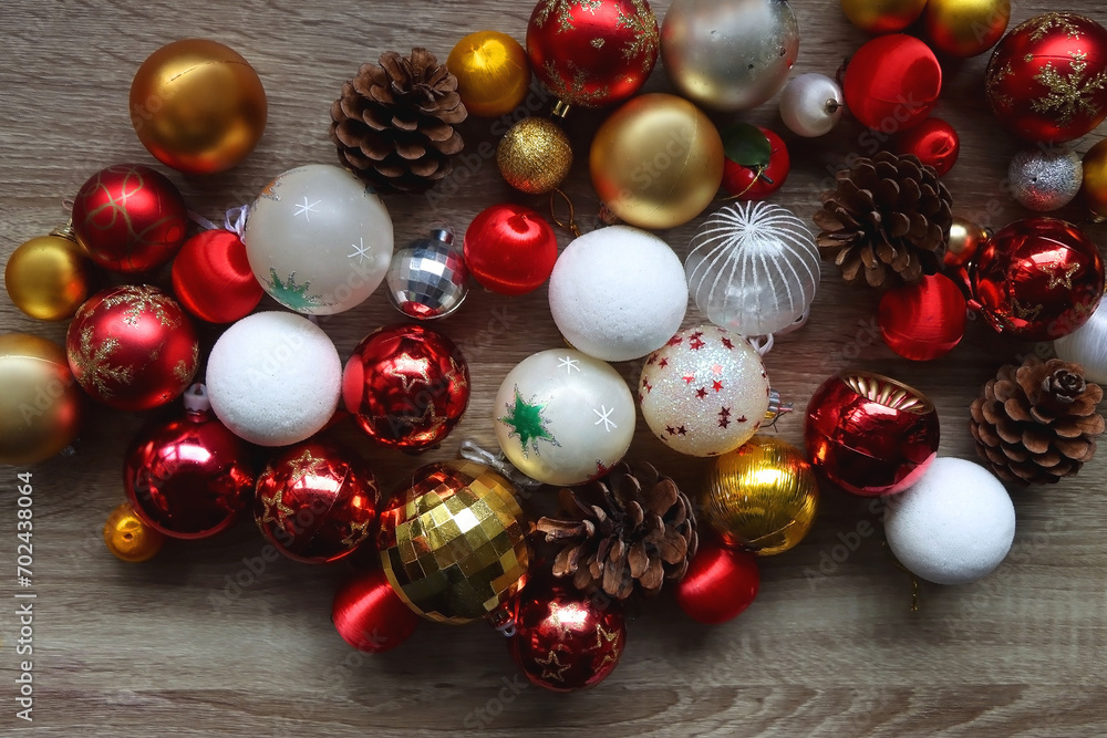 Pine cones and red, golden and white Christmas ornaments on wooden background. Top view. Pine cones and red, golden and white Christmas ornaments on wooden background. Top view.