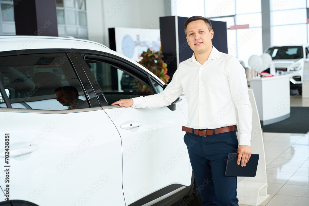 Customer service manager in office clothes stands by white car