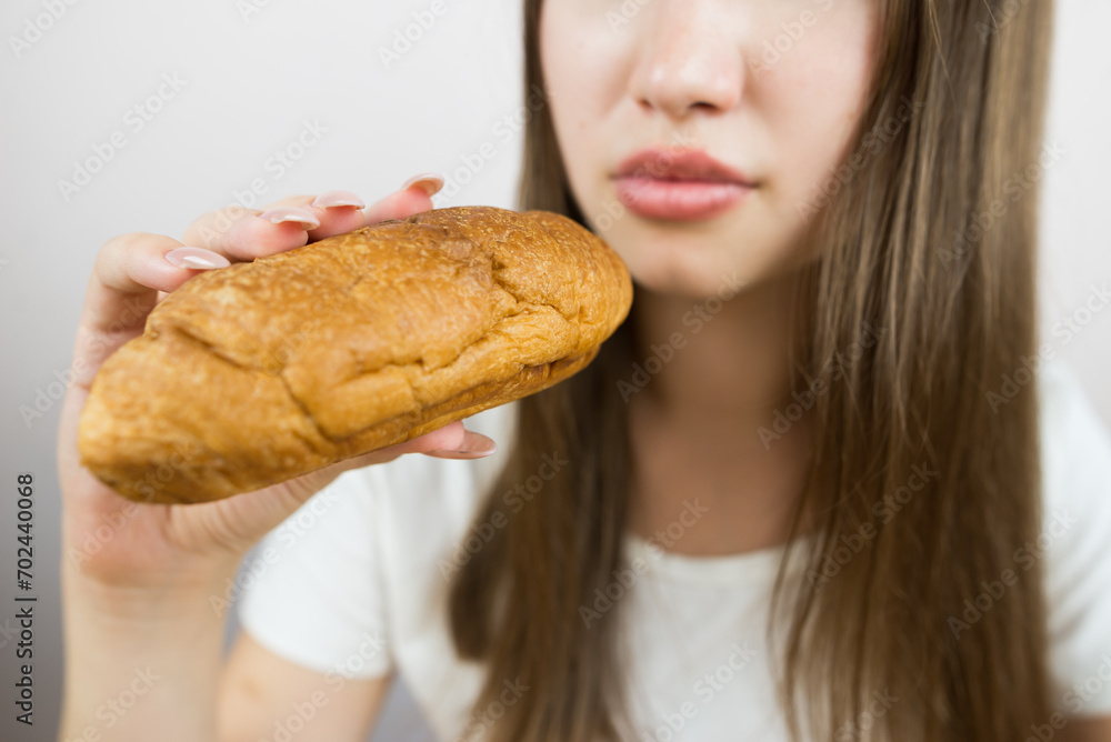 young beautiful girl eating a croissant, close-up, crop photo. female mouth eating croissant young beautiful girl eating a croissant, close-up, crop photo. female mouth eating croissant